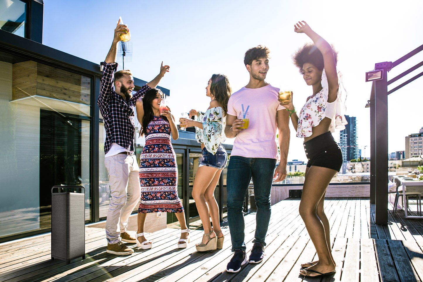 Vrolijke vrienden die samen feesten op een zonnig dakterras