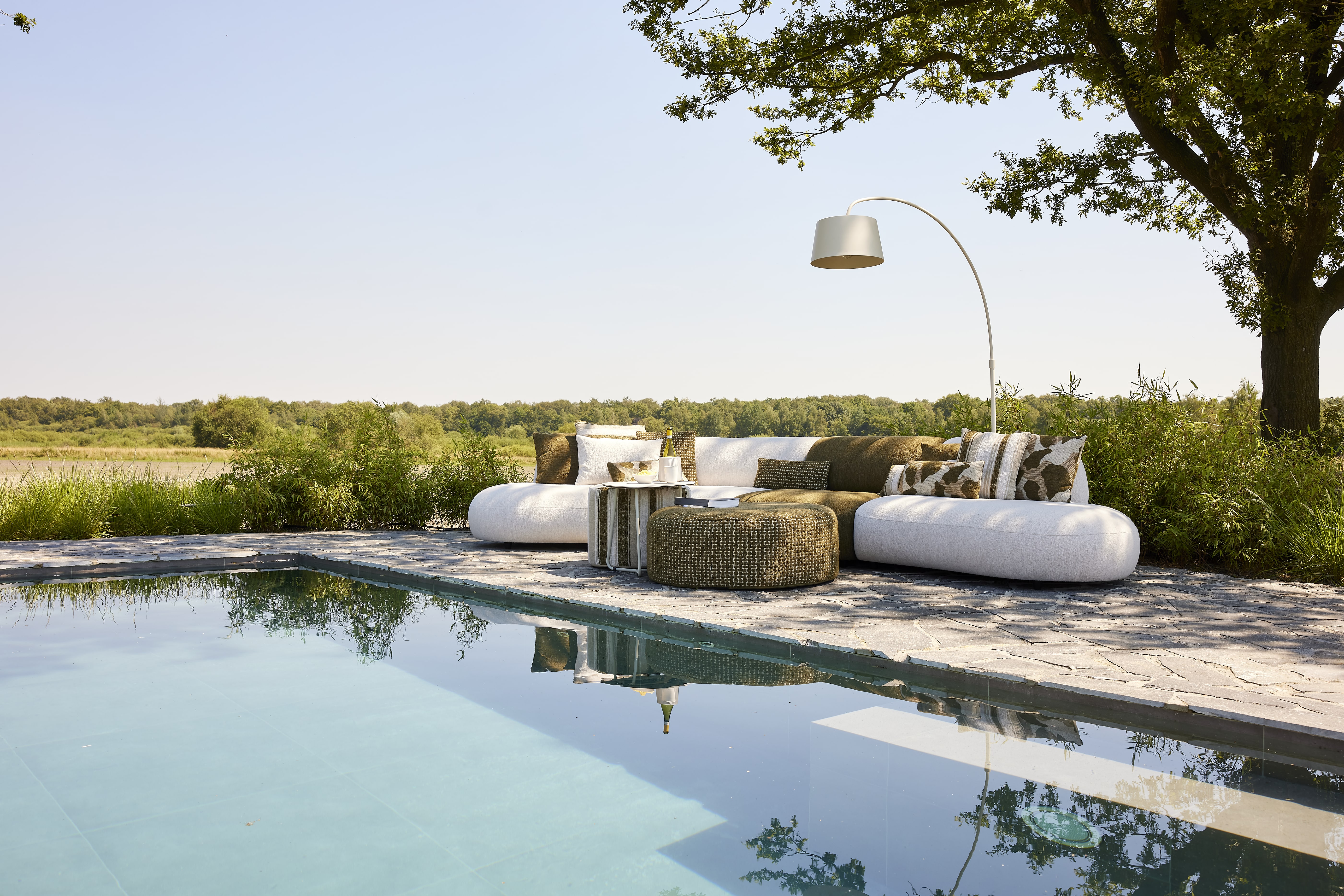 Stijlvolle buitenruimte met zwembad, loungebank en staande lamp