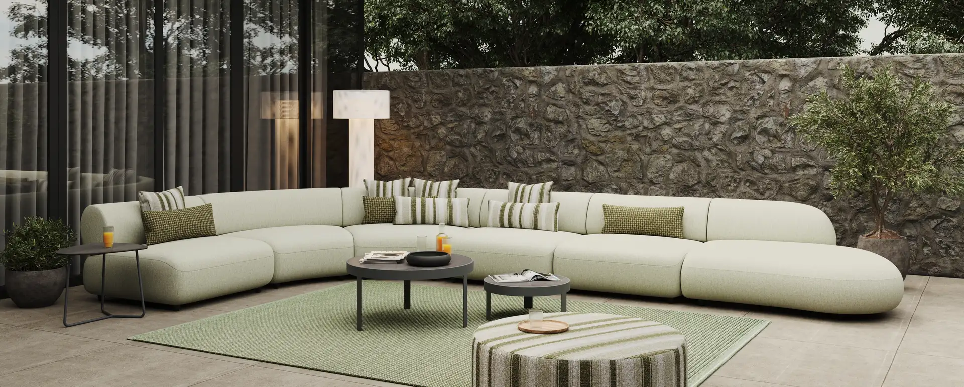 Moderne woonkamer met gebogen bank, groene accenten en natuurlijke stenen muur