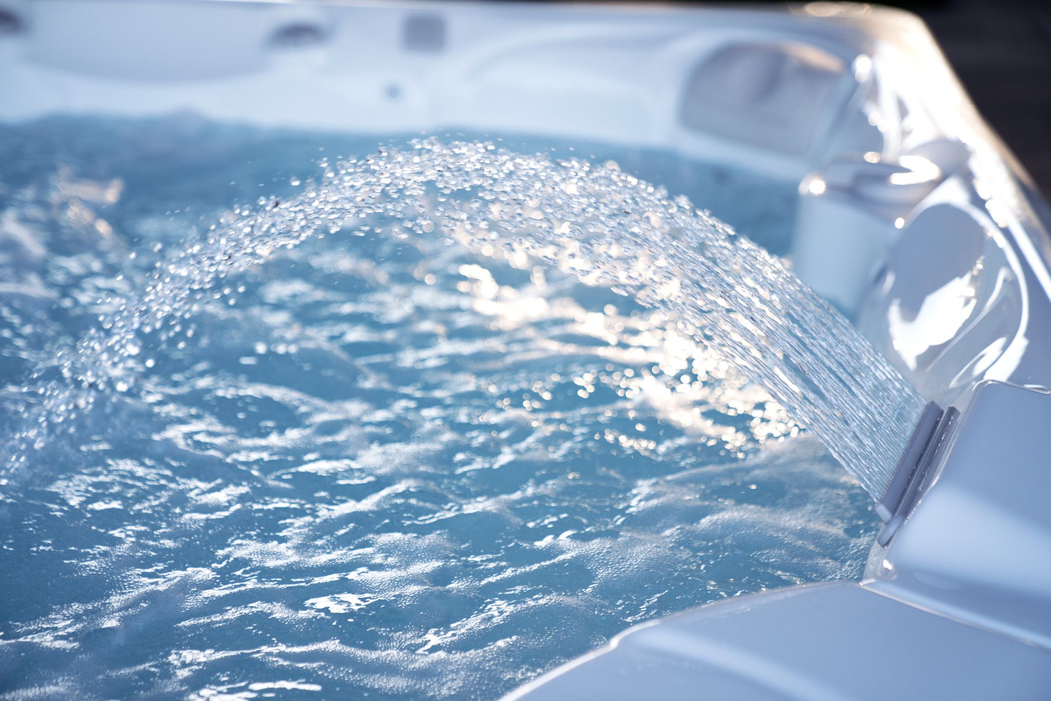 Blauwe caldera spa met fonkelend water en opspattende waterstralen