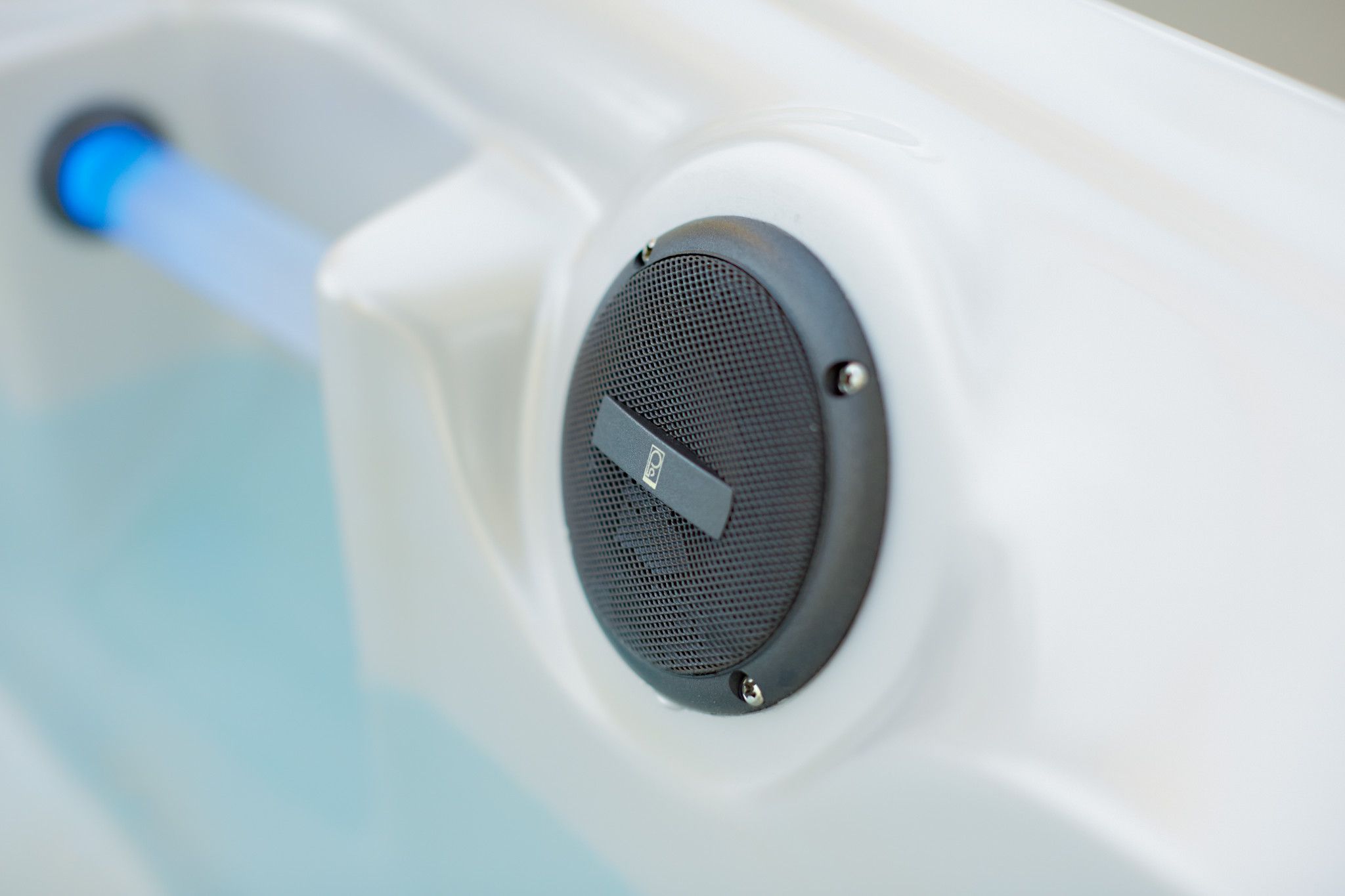 Blauwe caldera spa-speaker met rooster in wit oppervlak gemonteerd