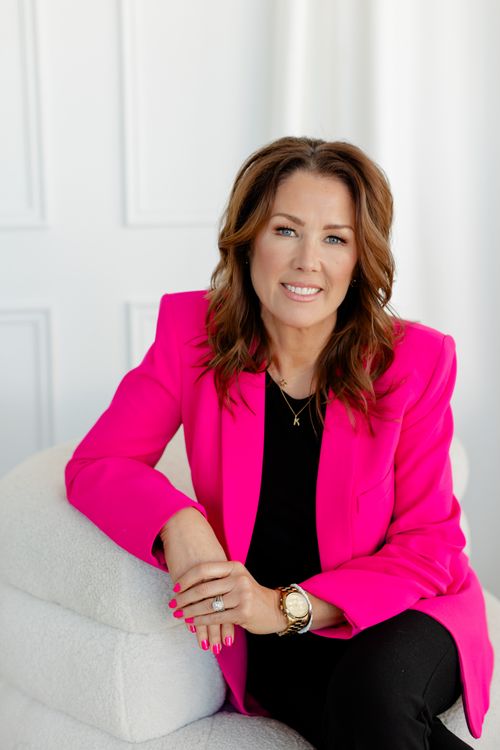 Photo of Karen Kelly standing, smiling in an office