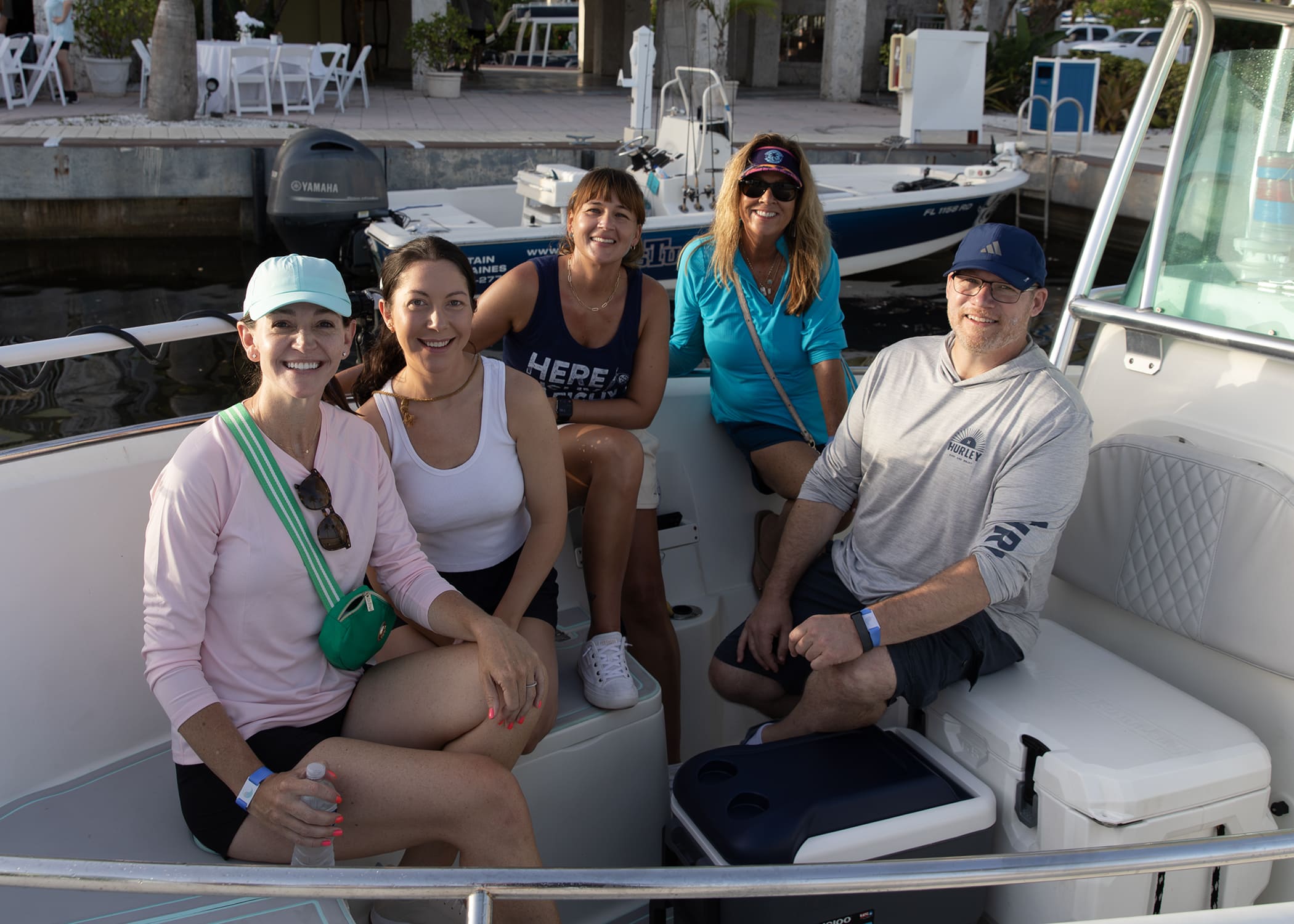 Group of women sitting together on a boat docked at the marina.