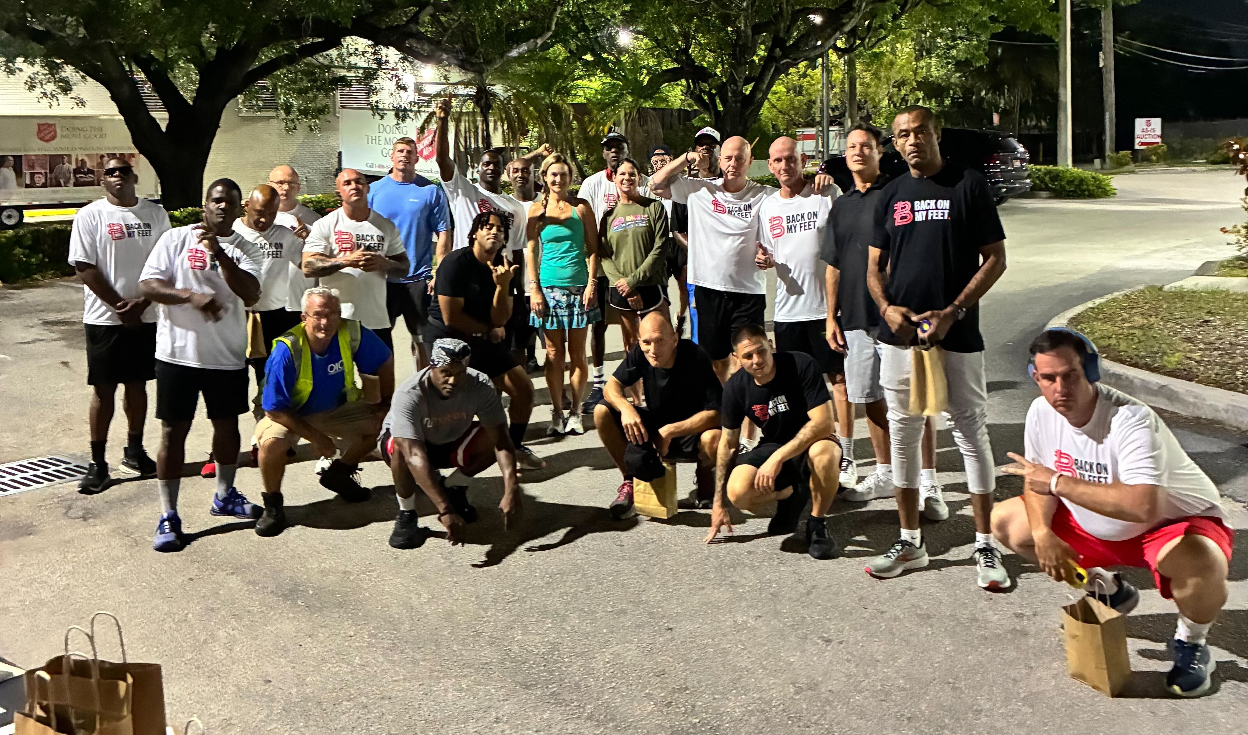 Group of Back on My Feet members posing together outdoors at night