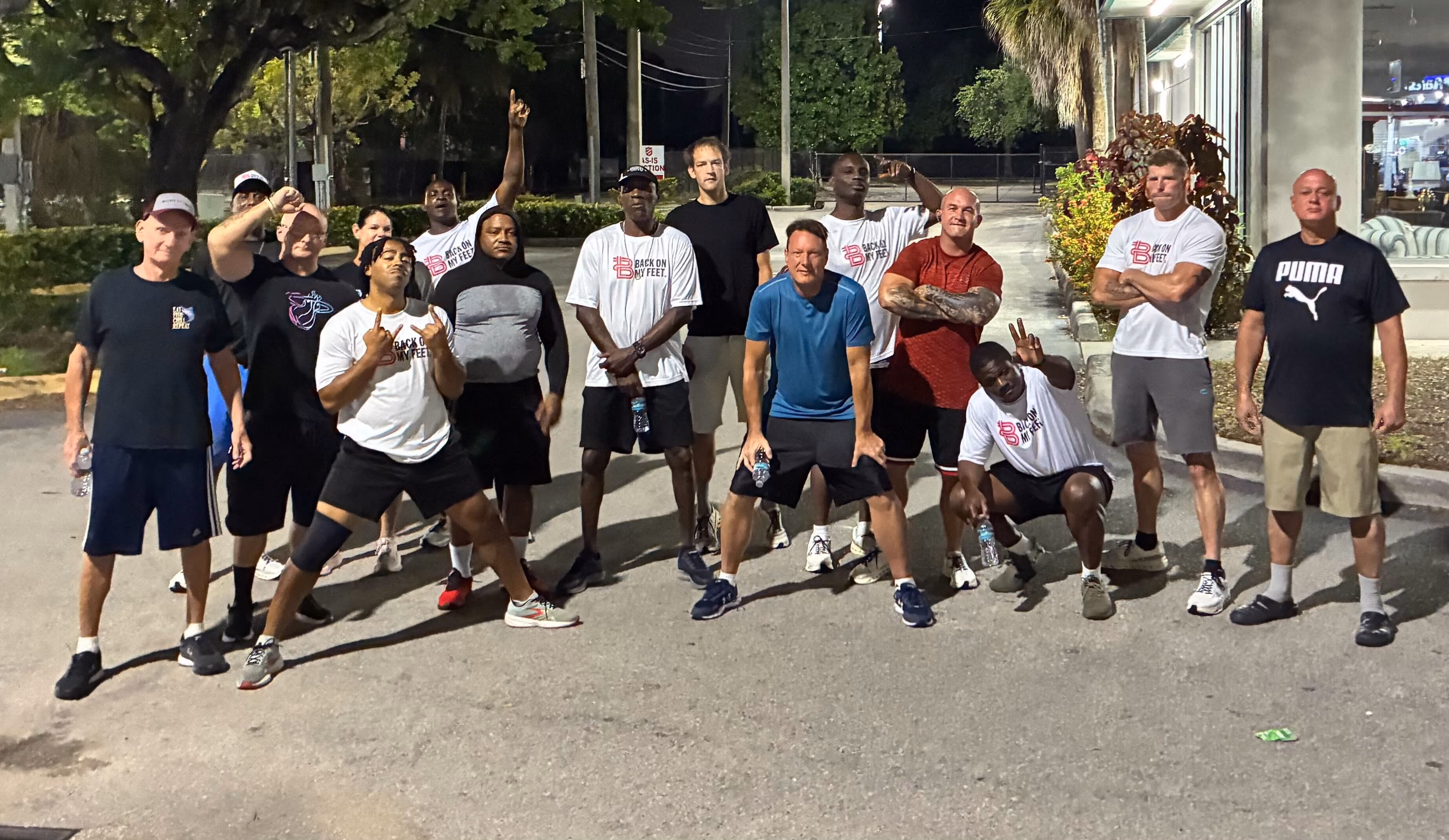 Group of Back on My Feet members posing together outdoors at night after a run