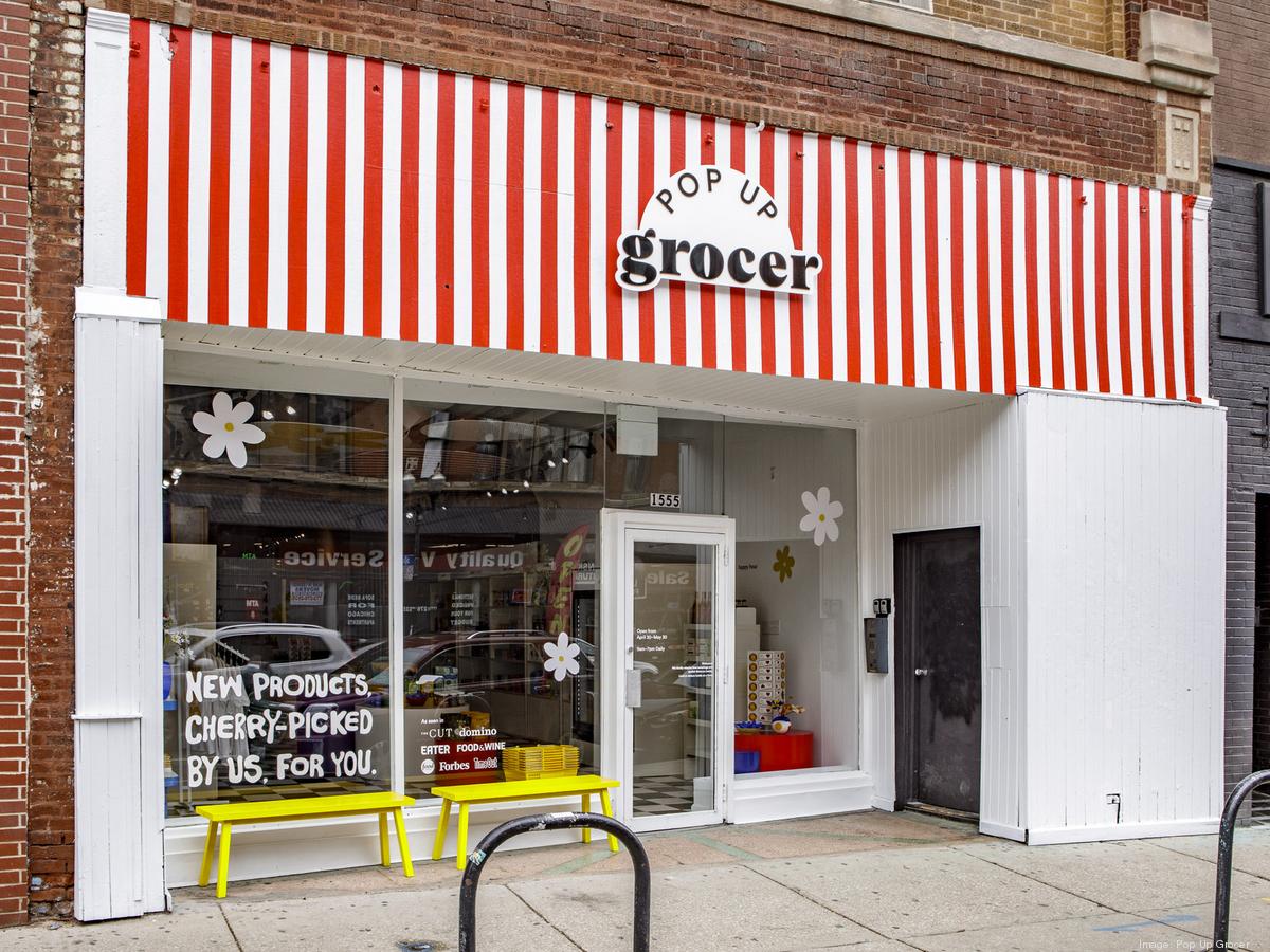 A small store with a red and white striped banner and the words ‘Pop Up Grocer’.