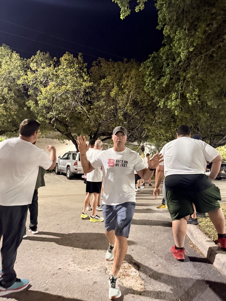 Runners in white shirts cheering with raised arms