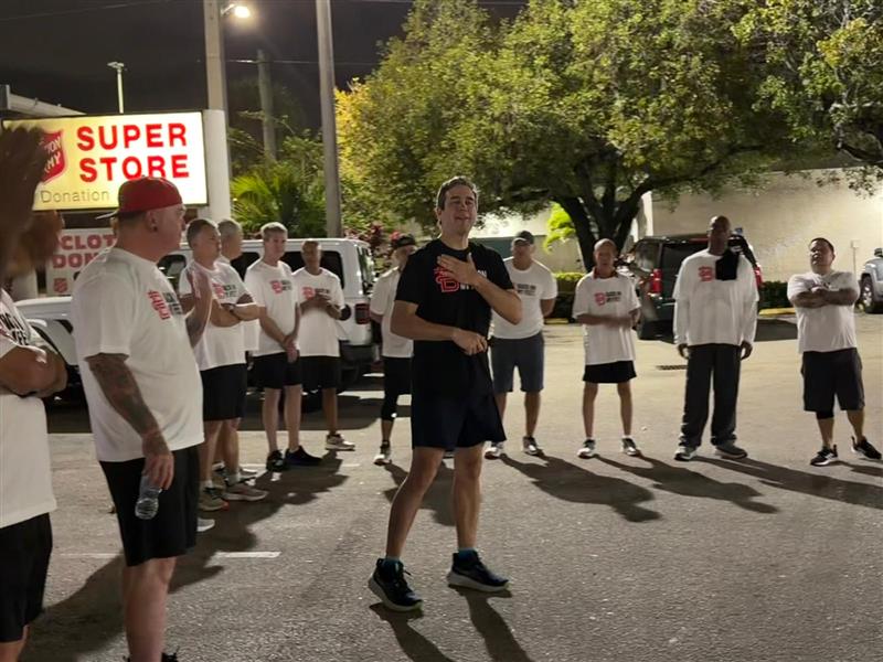 Group of runners standing in formation in a parking lot at night
