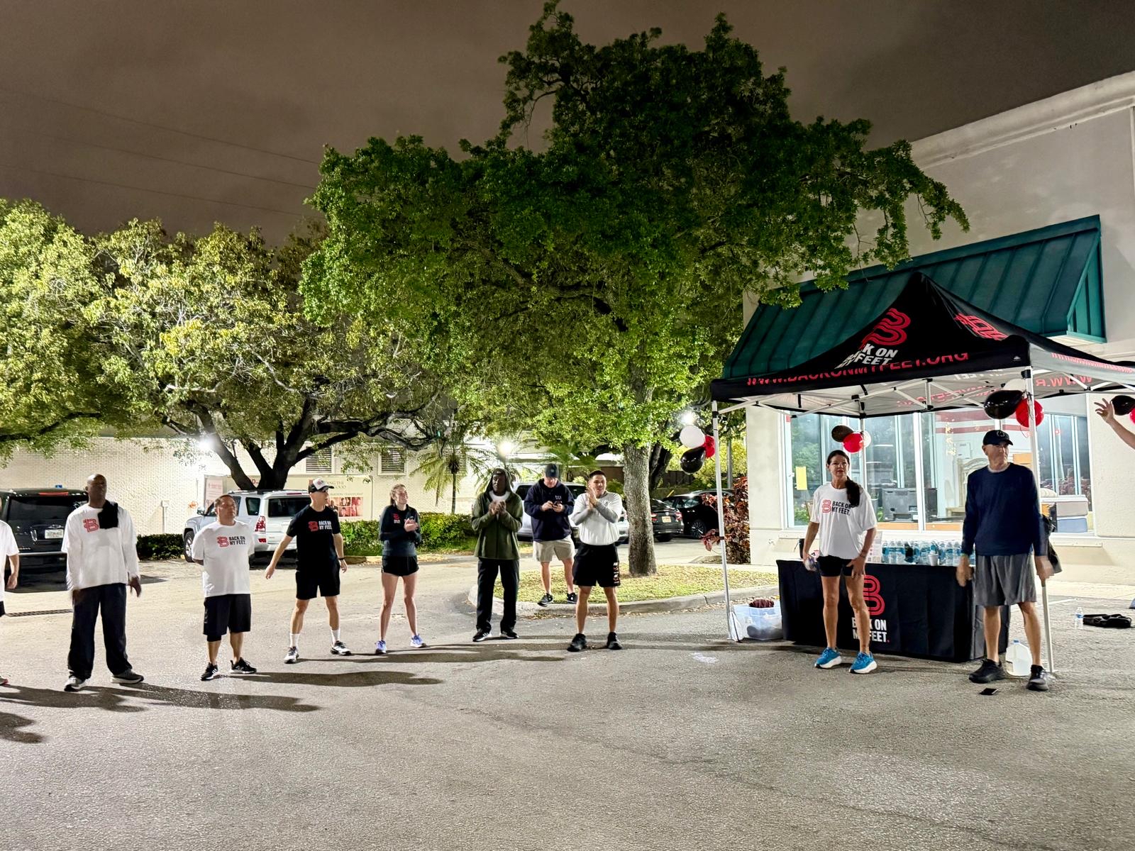Runners heading out from the event tent along a dark street