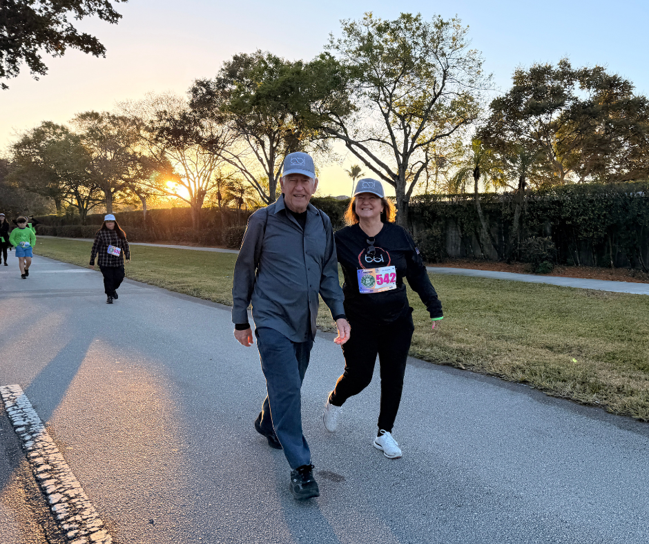 Walkers with race bibs on a tree-lined path