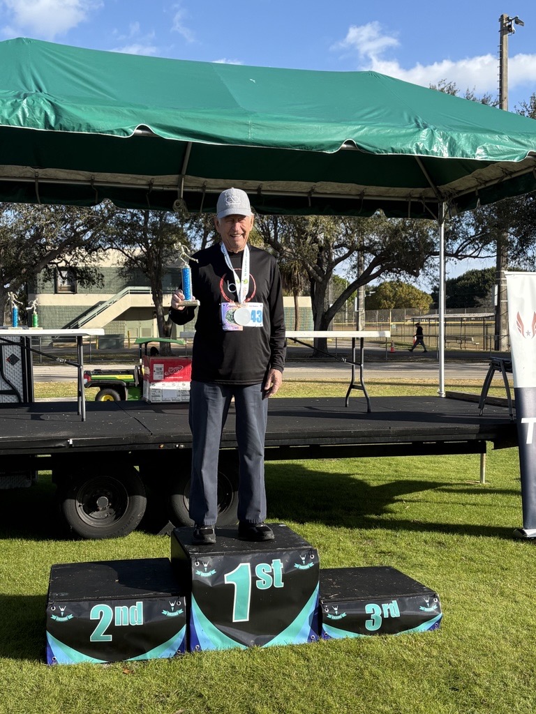 Man with a race bib standing beside the event stage