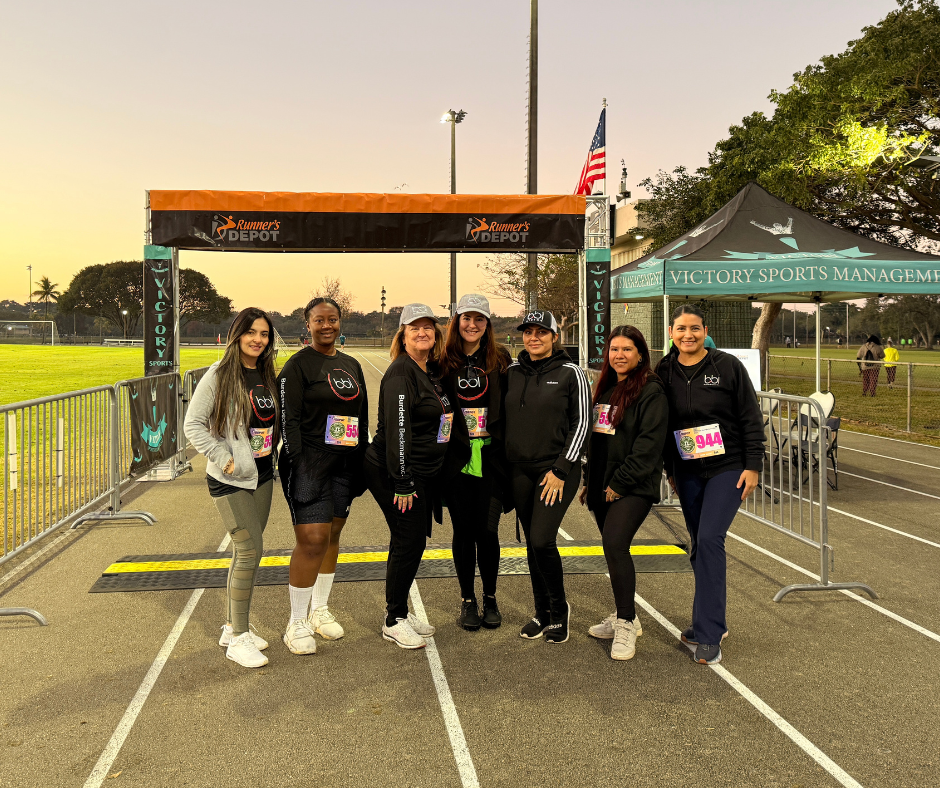BBI team posing in front of the finish line arch