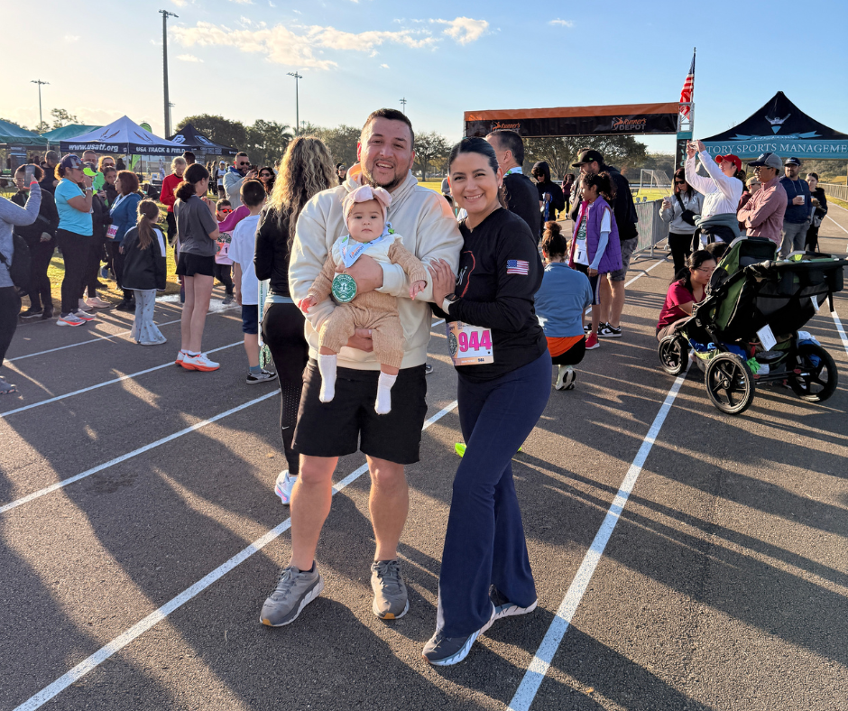Participants smiling with a baby on the course