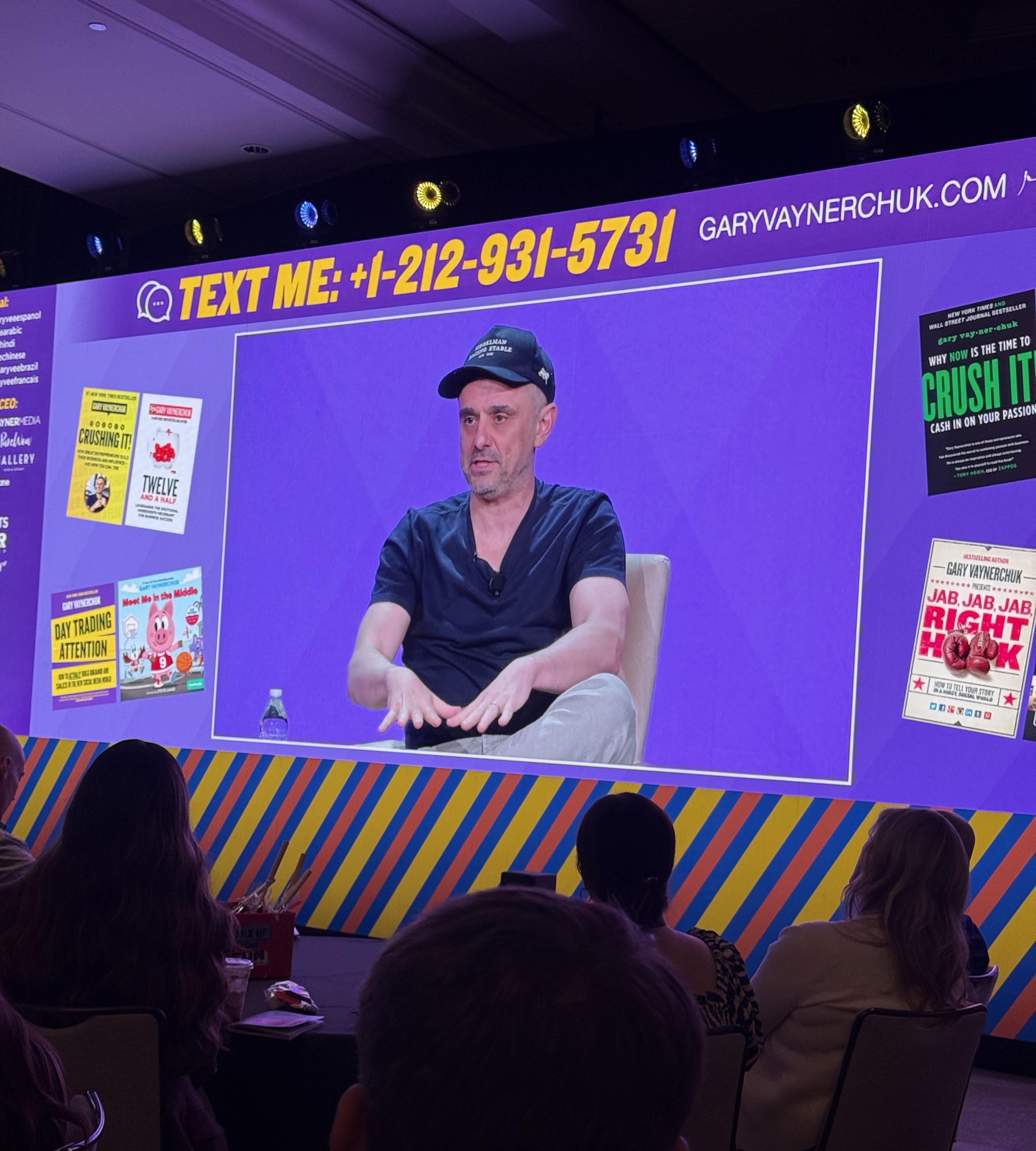 Speaker in a baseball cap shown on the conference screen