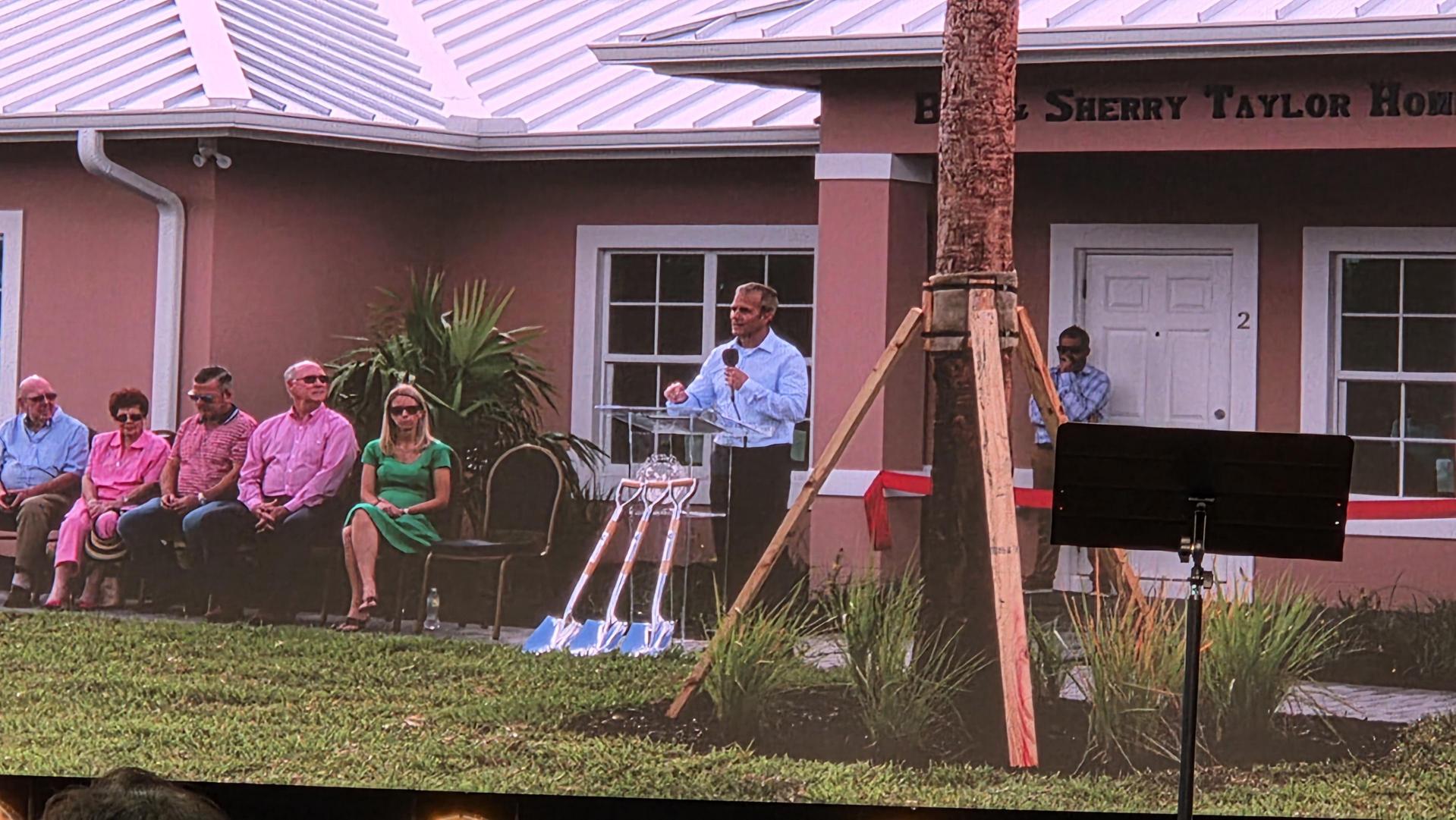 Guests seated outside the new home during the ceremony