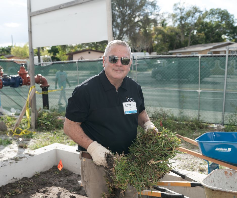 Volunteer in work gloves landscaping at the build site