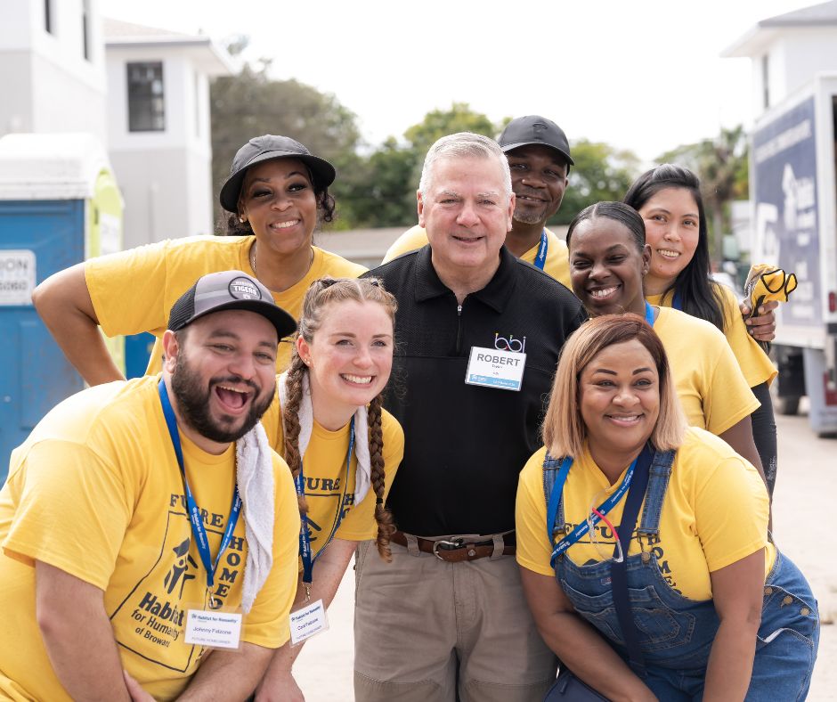 Volunteers in yellow and black BBI shirts smiling together