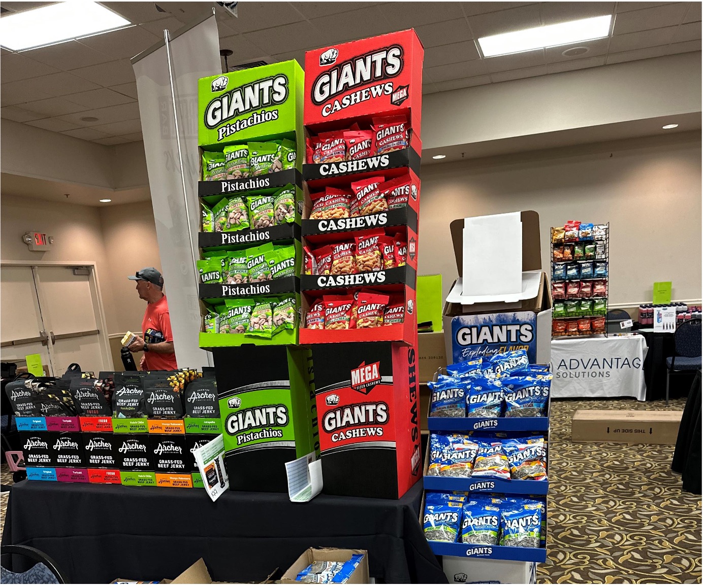 Giants Pistachios and Cashews display towers next to rows of Archer beef jerky on a table.