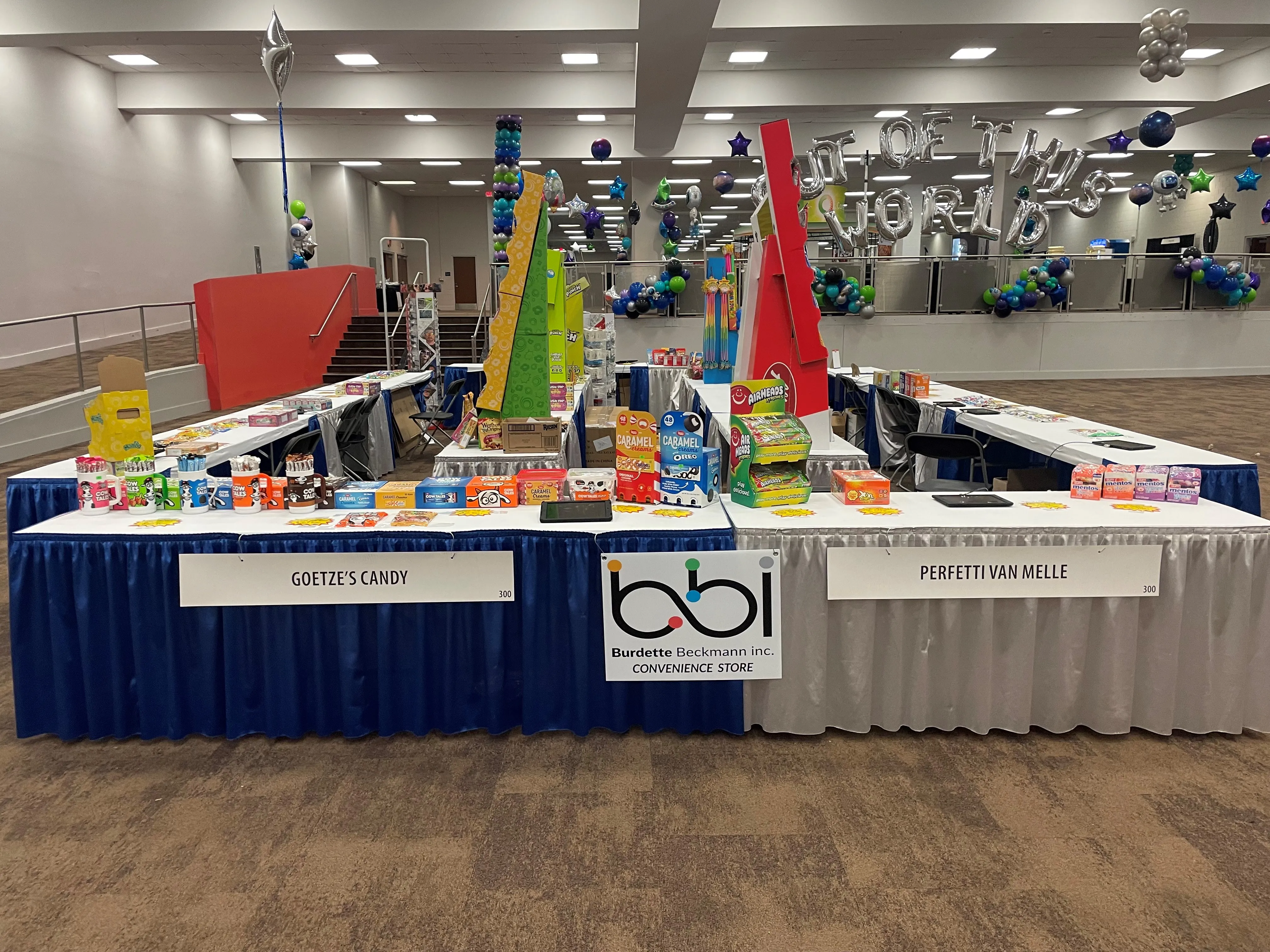 Vendor tables with a bbi Convenience Store sign between Goetze's Candy and Perfetti Van Melle placards.