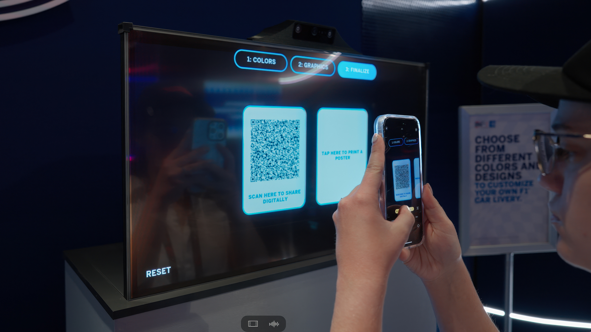 A visitor scanning a QR code on the touchscreen to digitally save their customized Formula 1 car livery.