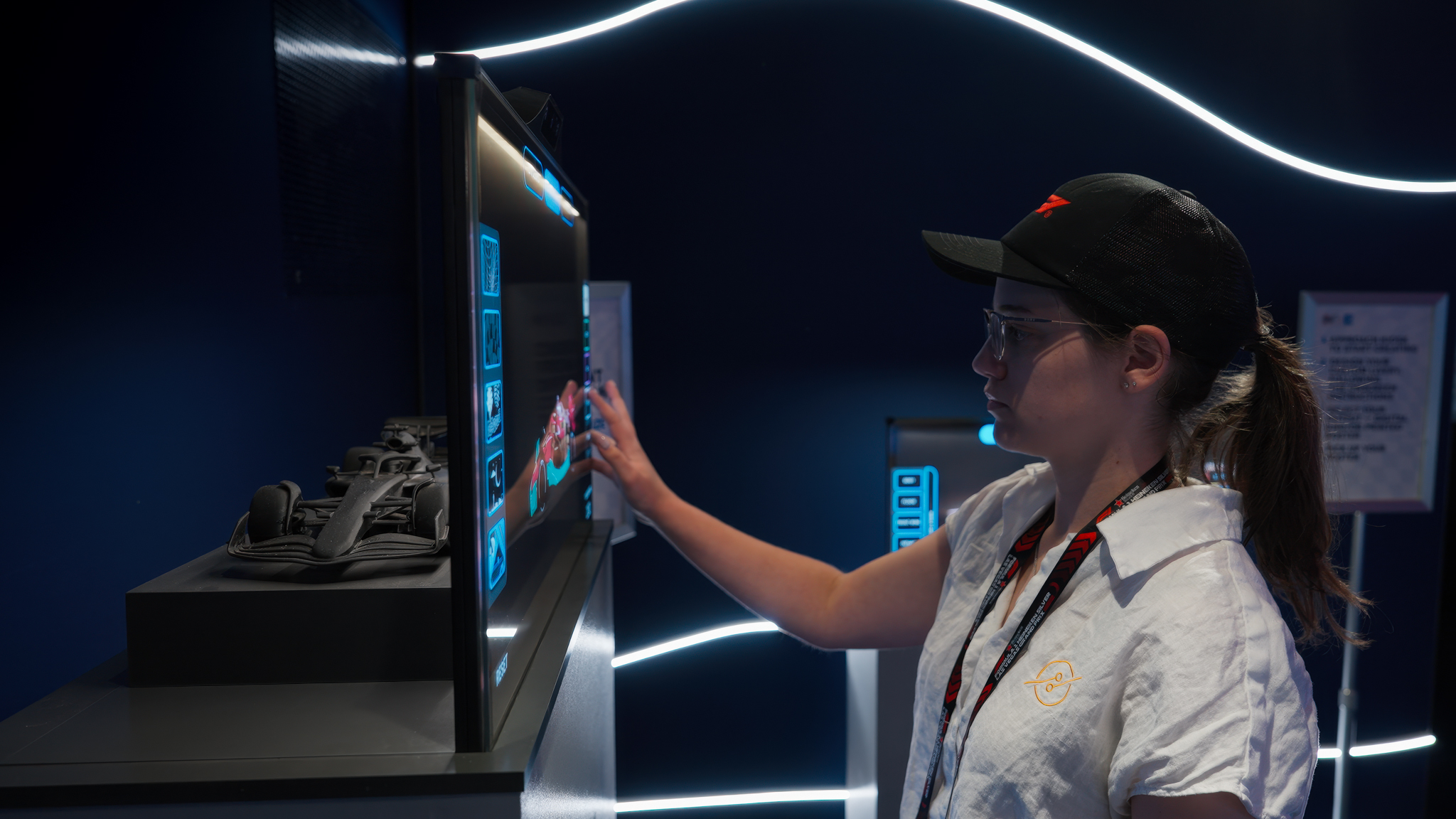 A participant interacting with the F1 livery customization screen, adjusting colors and design options.