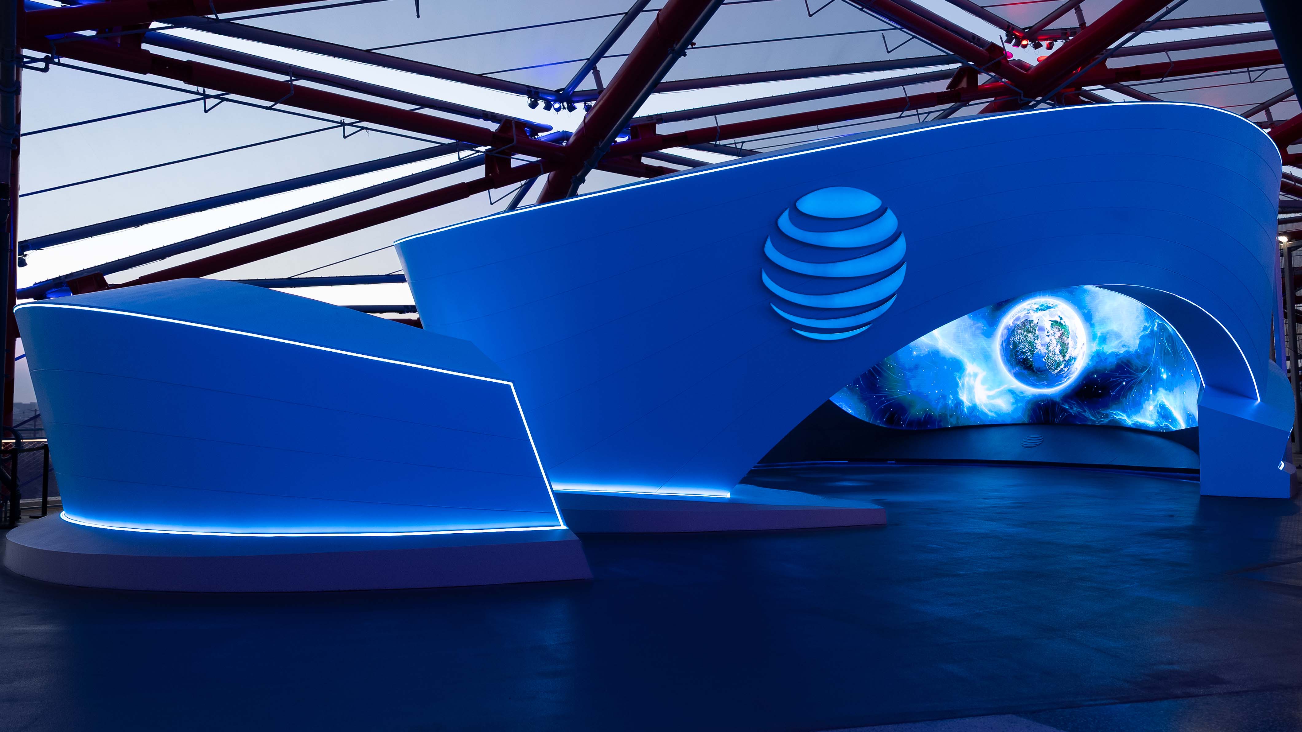 A WWII-themed wall display for The National WWII Museum in New Orleans, featuring three hexagonal frames. The frames showcase historical images of soldiers and important moments, along with the museum's logo. The display is set against a grey, angular-patterned wall with a sleek, modern design.