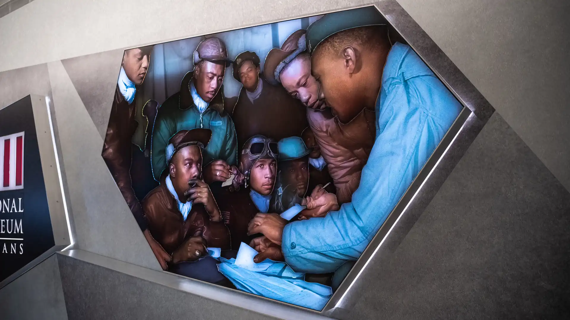 Colorized portrait of Tuskegee Airmen illuminated within the Watercolors installation’s angular frame.