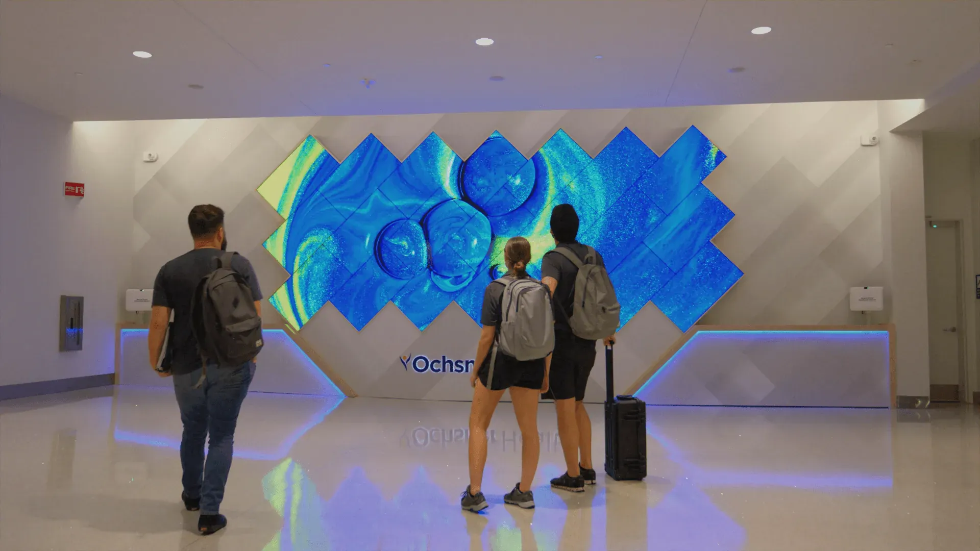 Travelers viewing Ochsner Health’s mosaic video wall at New Orleans International Airport.