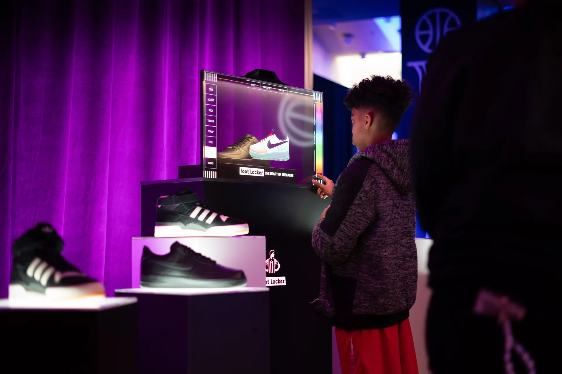 Visitor customizing a sneaker using Luminary's LENS transparent OLED augmented reality kiosk at the Foot Locker All Star Weekend activation.