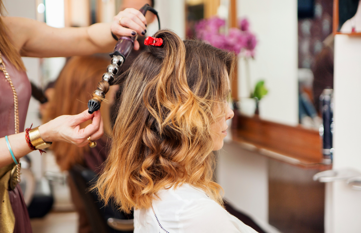 Cosmetology student practicing styling technique at Beyond 21st Century Beauty Academy, comparison with Golden West College program