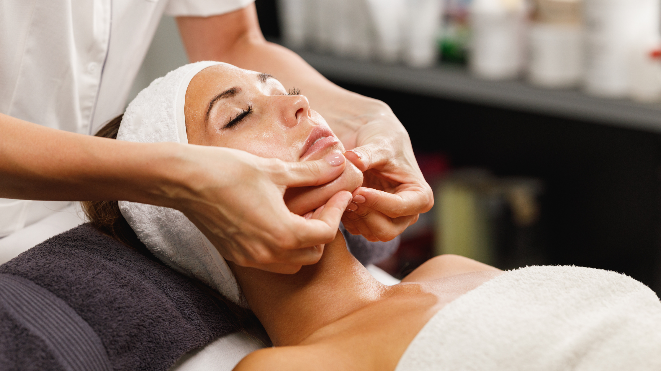 Esthetician student practicing a facial treatment on a client in a supervised student clinic setting