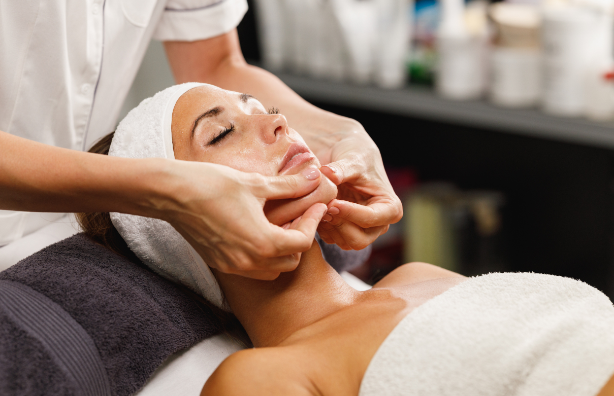 Esthetician student practicing a facial treatment on a client in a supervised student clinic setting