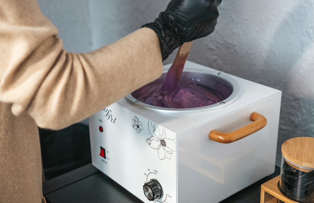 Esthetician student preparing wax for client in the Beyond student salon during class