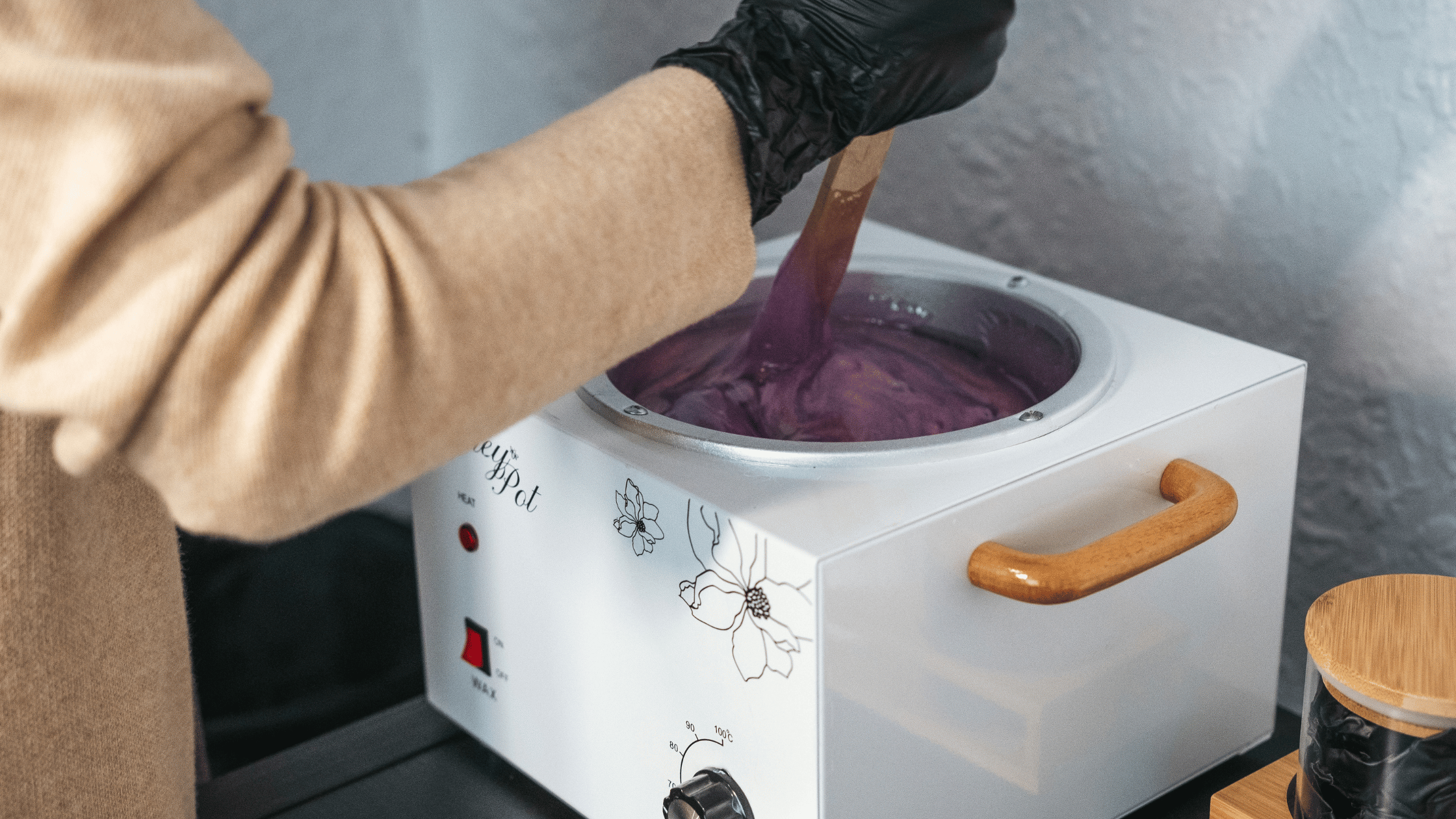 Esthetician student preparing wax for client in the Beyond student salon during class