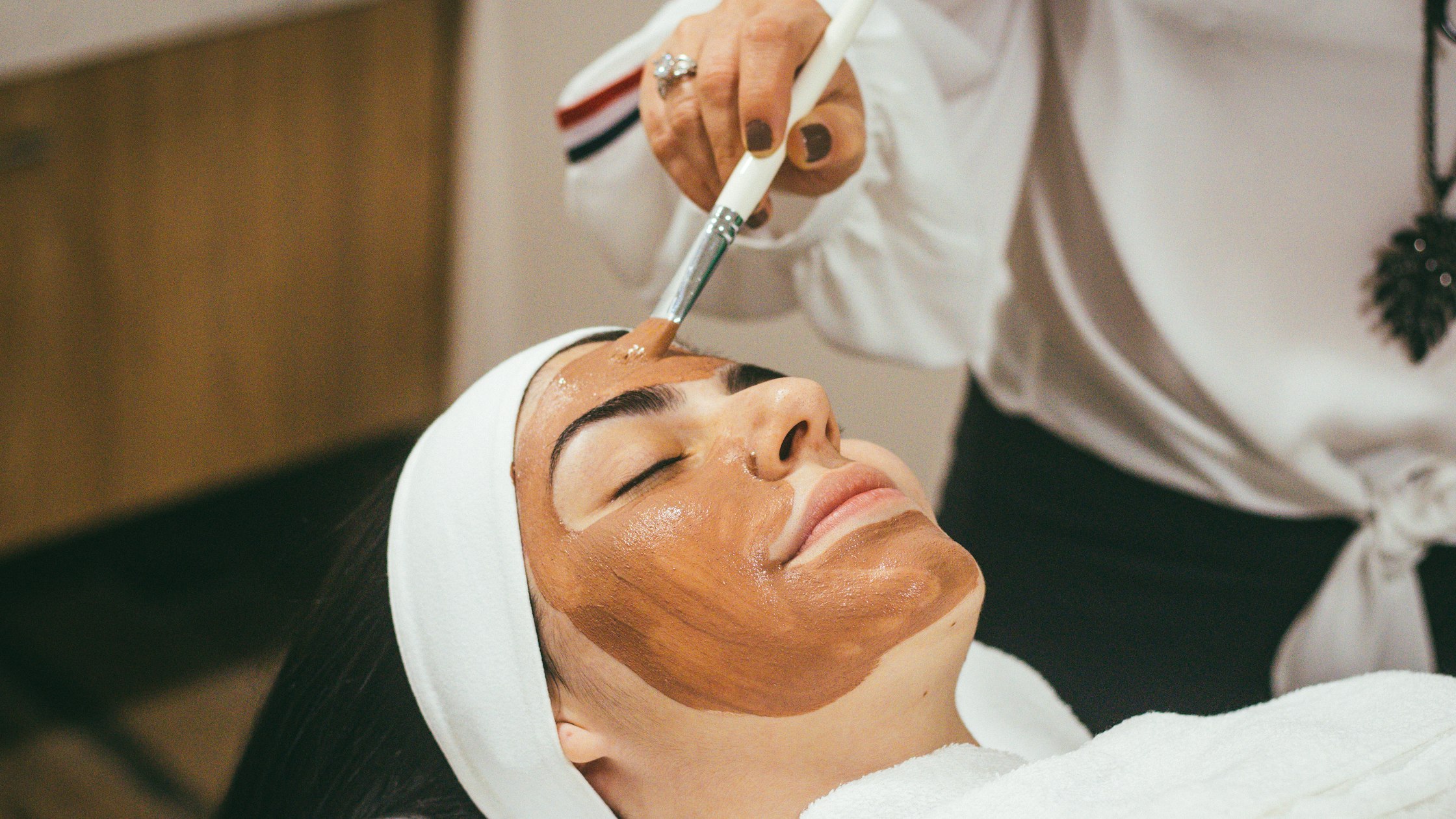 Esthetician student checking her class schedule between facial treatments at a California beauty school