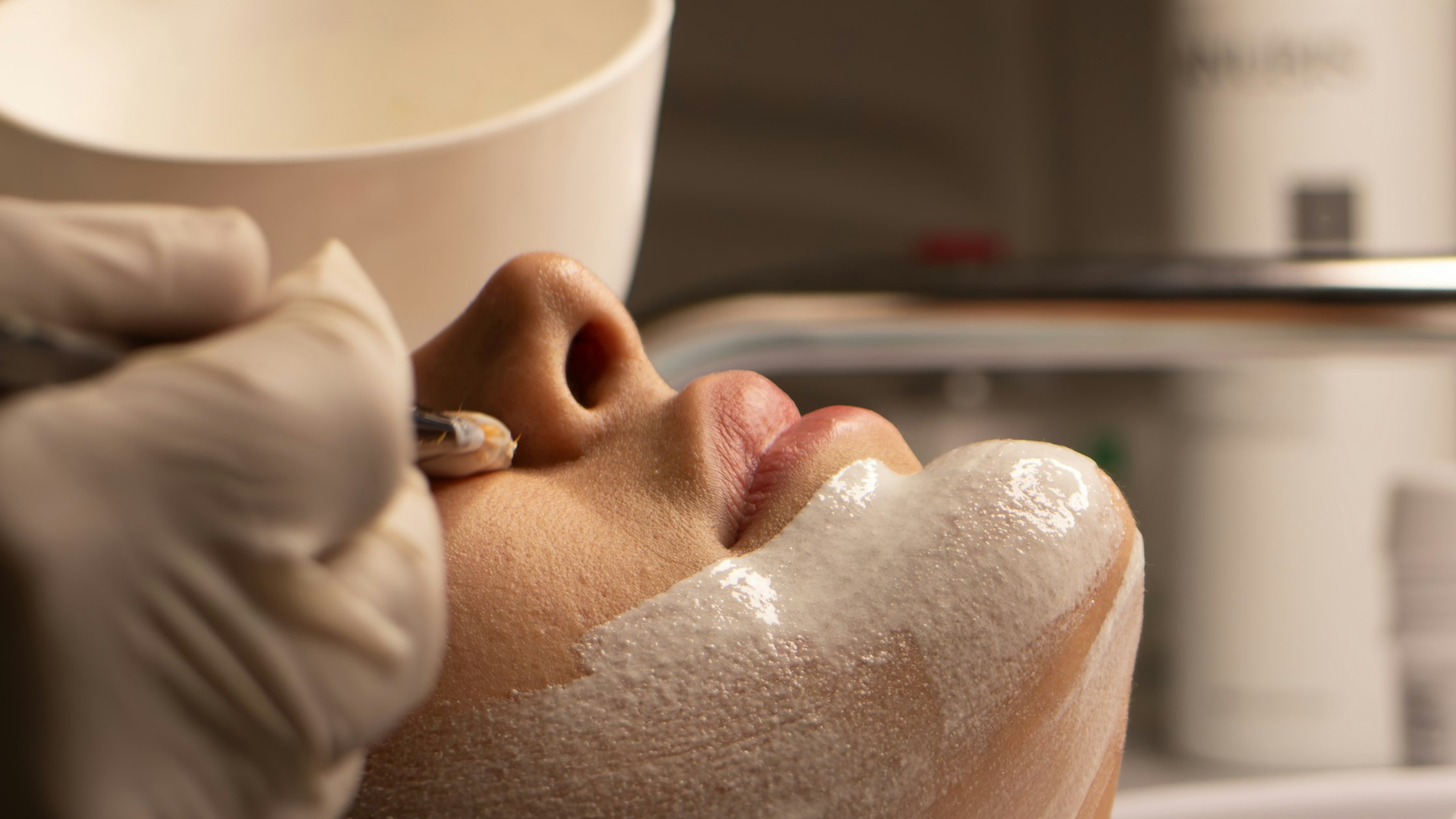 Esthetician performing a professional facial treatment on a client in a skin care studio