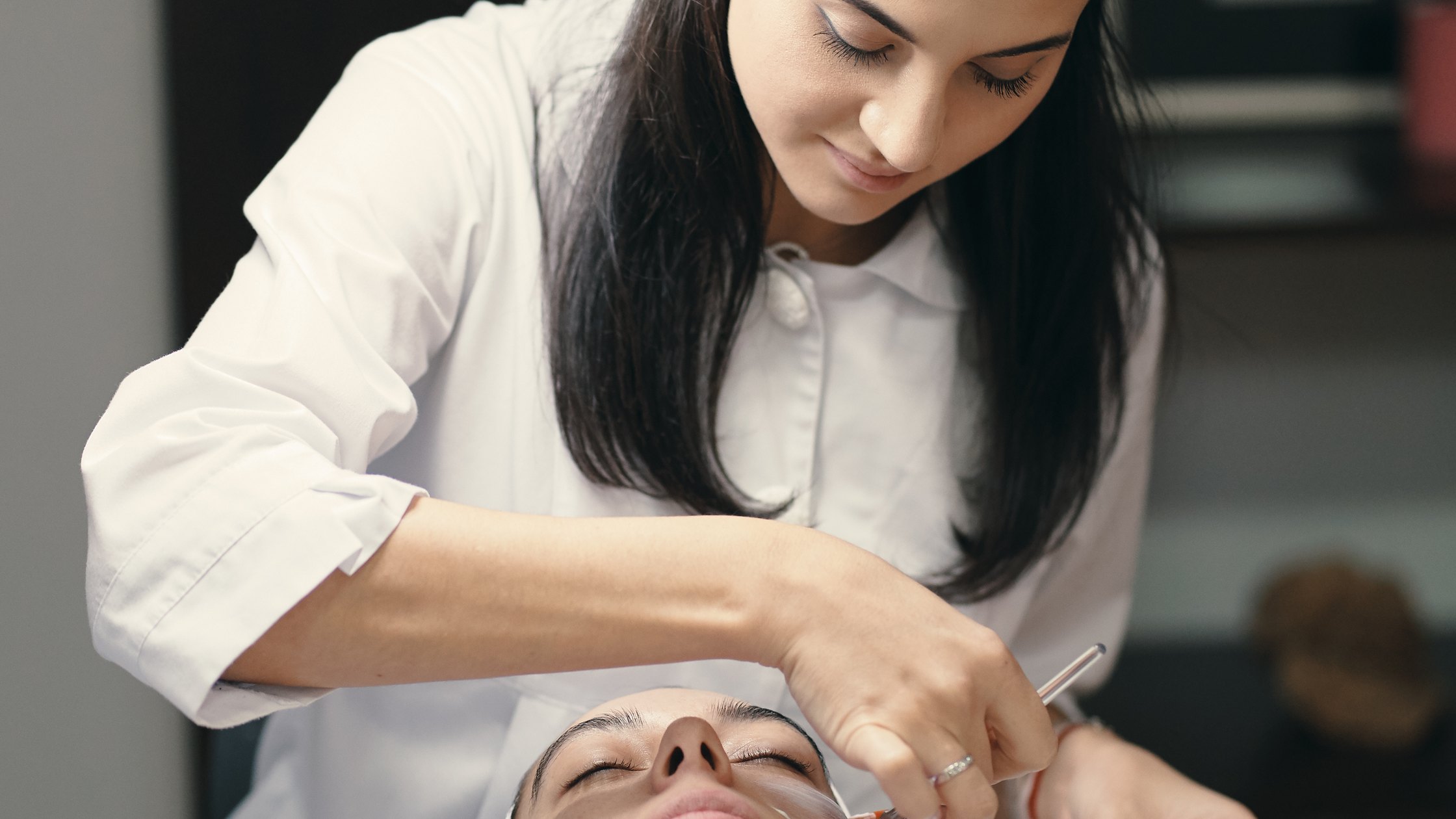 Esthetician performing a facial treatment on a client in a spa setting