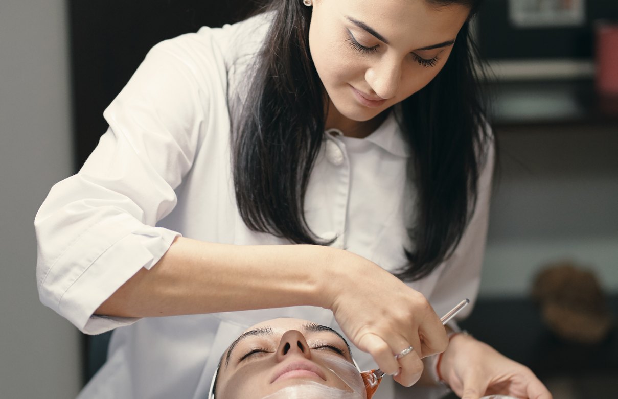 Esthetician performing a facial treatment on a client in a spa setting
