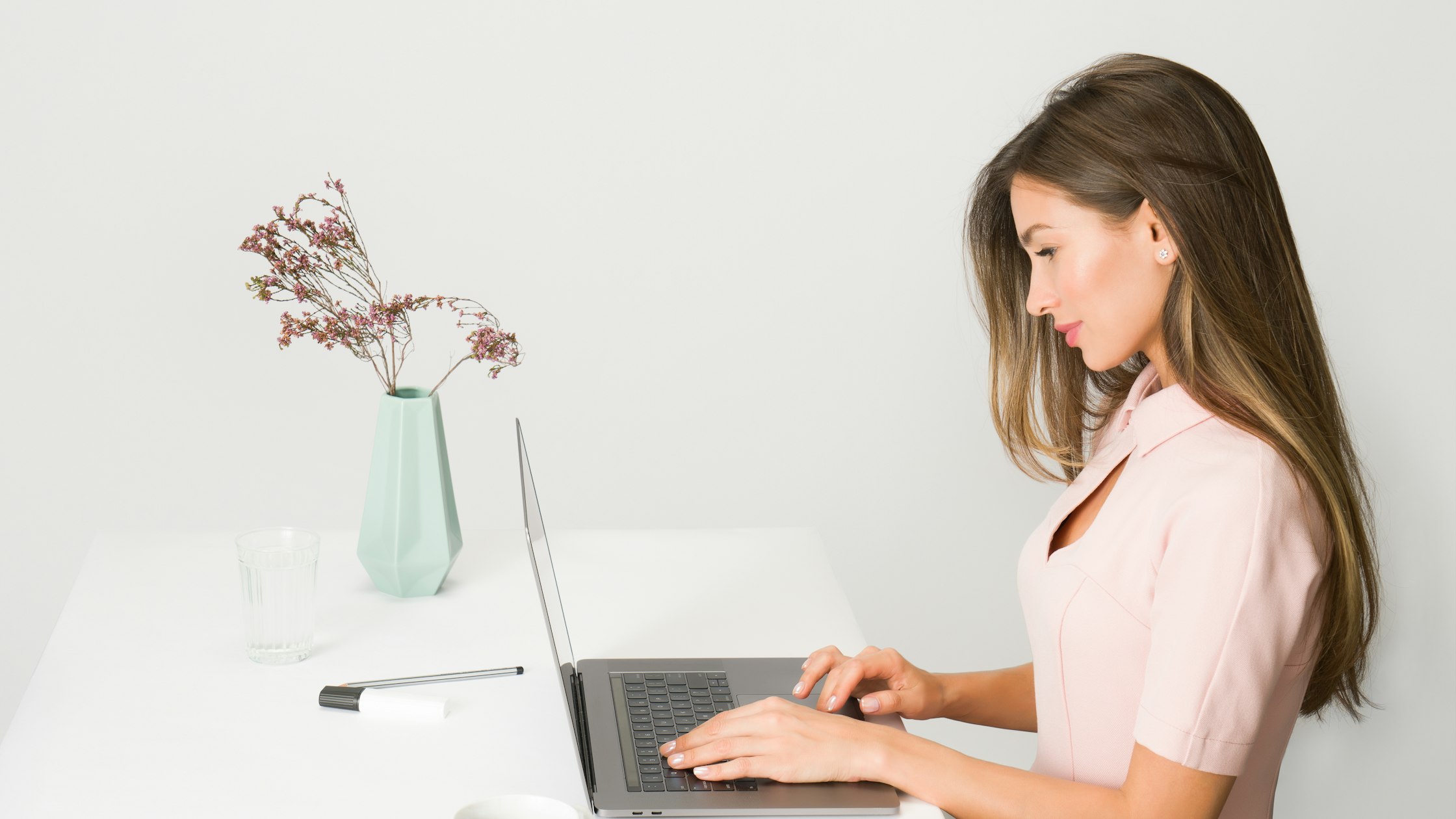 Cosmetology student studying on a laptop while preparing for the California State Board written exam