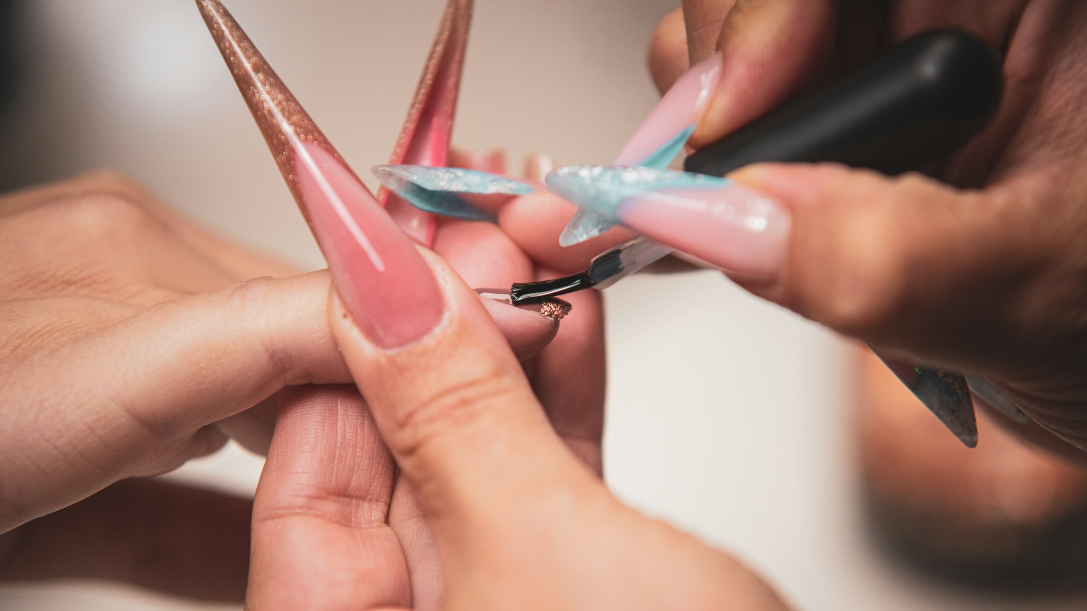 Manicurist painting long artificial nails