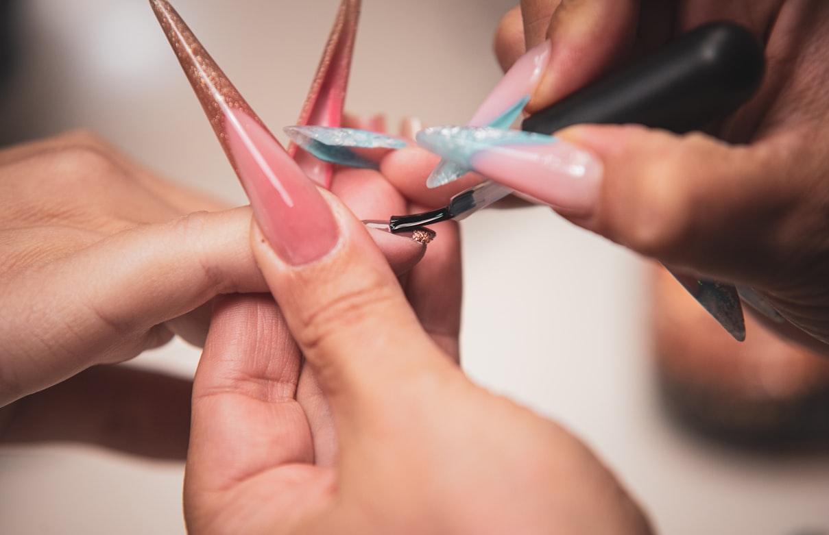 Manicurist painting long artificial nails