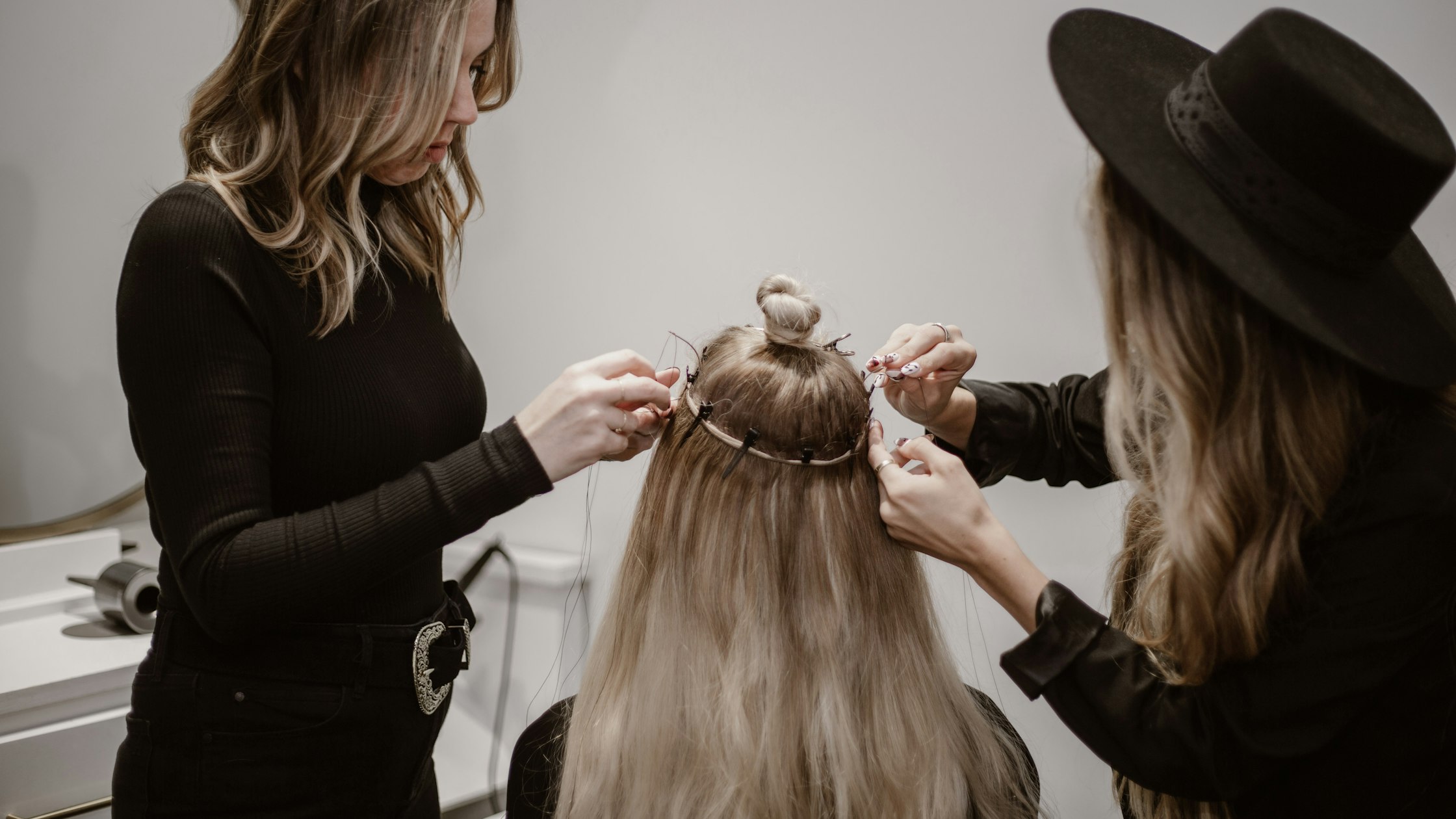 Stylist styling a client's hair in a salon, the hands-on training at the heart of cosmetology school
