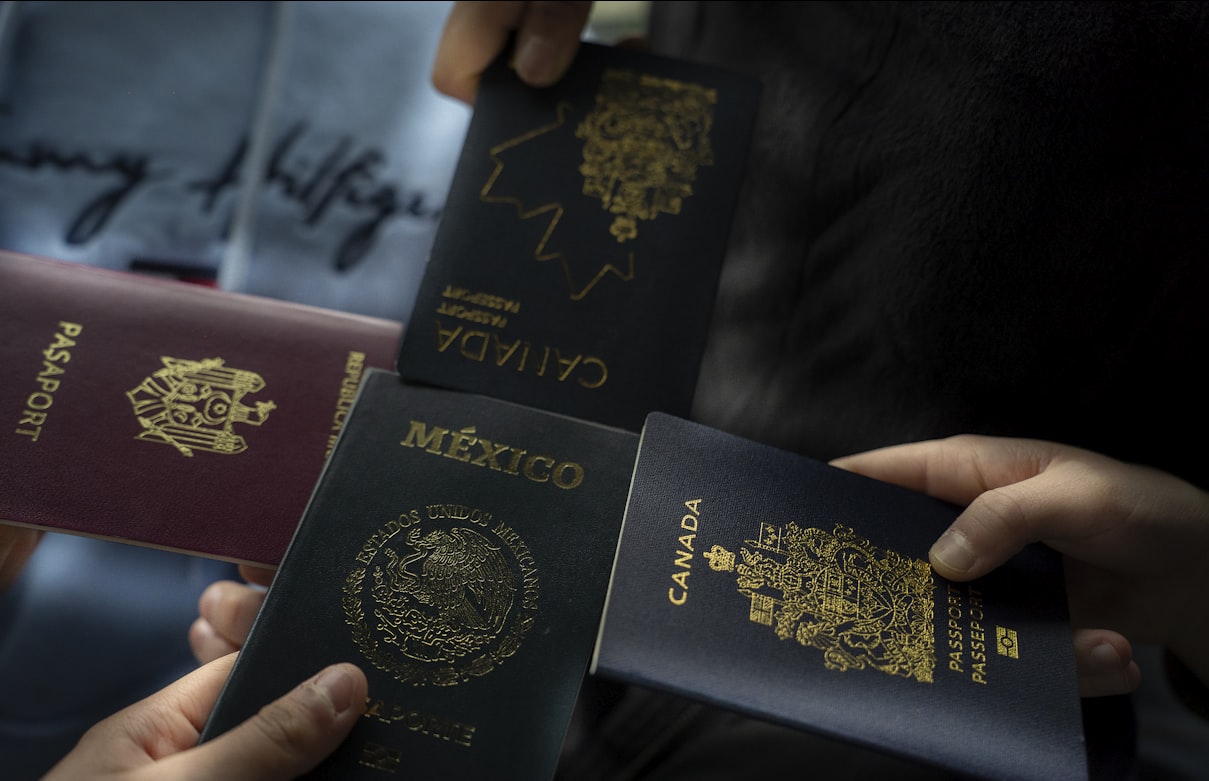 Four people holding passports from different countries, representing non-citizens who qualify for FAFSA at beauty school