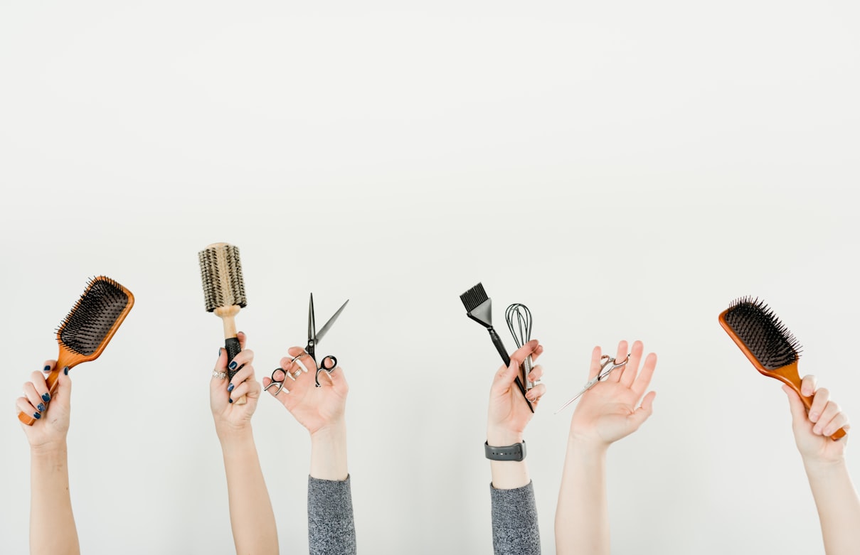 A stylist holding a professional hair brush alongside salon styling tools