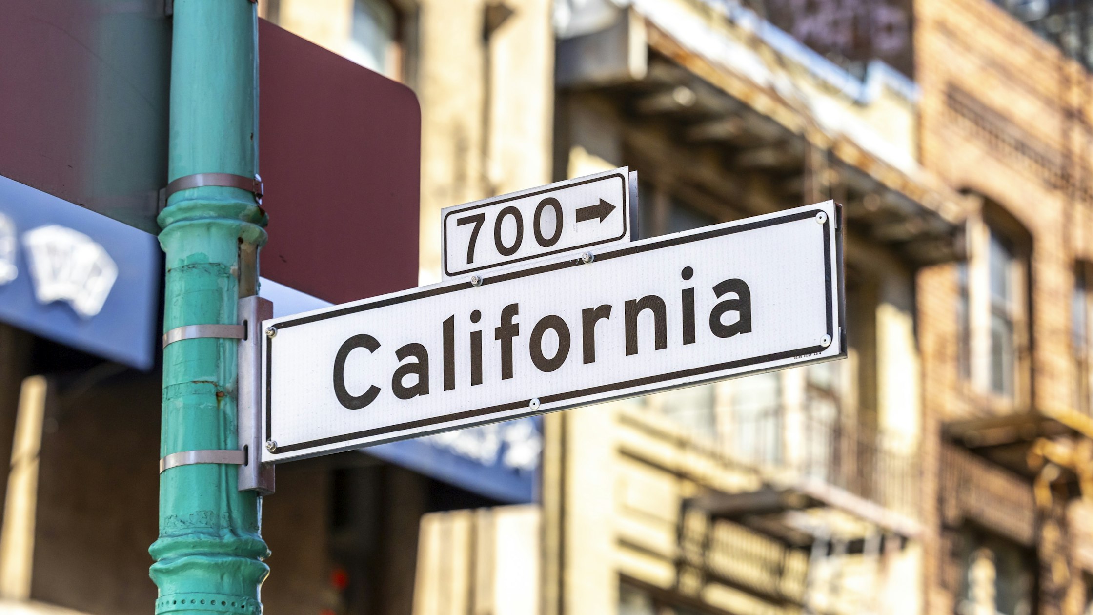 A California street sign with a building in the background