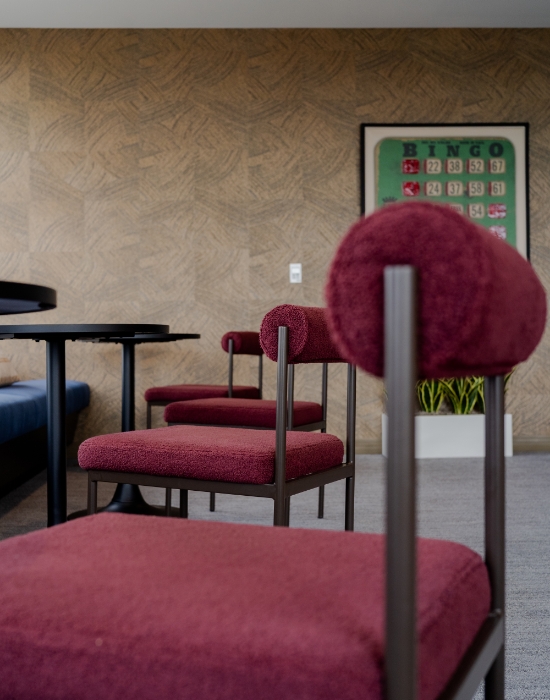 Red stools and booth seating with artwork on wall