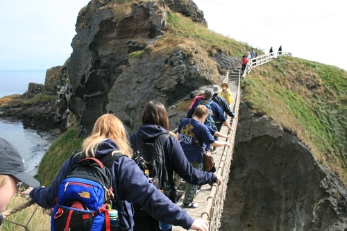 Students walk across a rope bridge in Northern Ireland