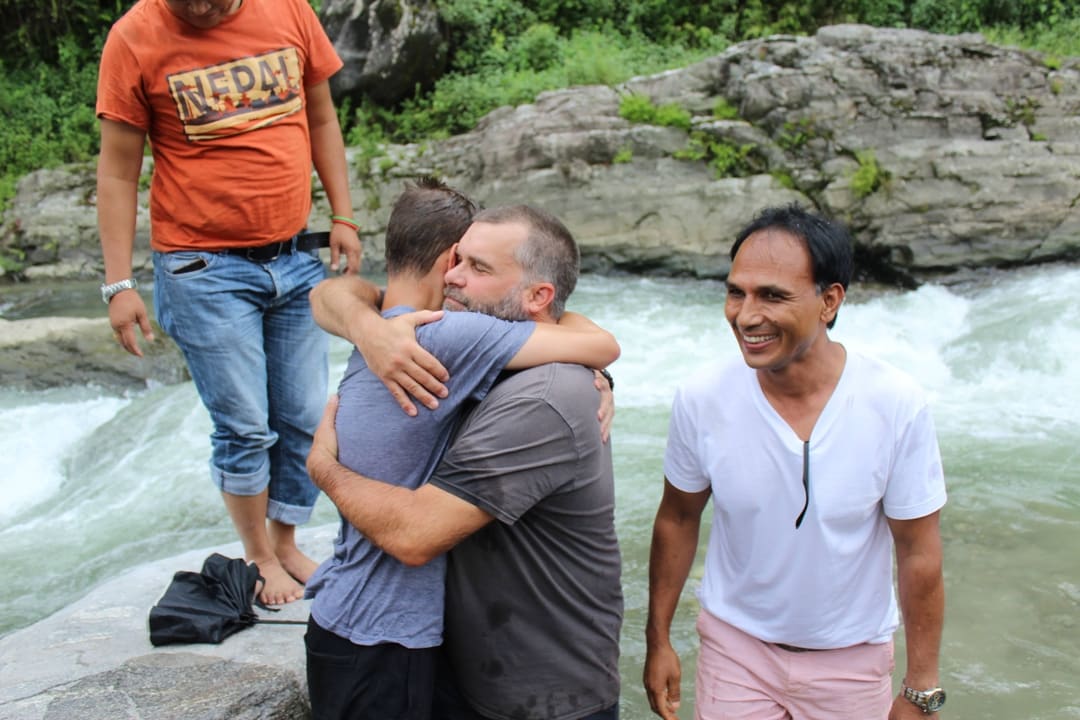 A trip leader hugging a student that was just baptized.