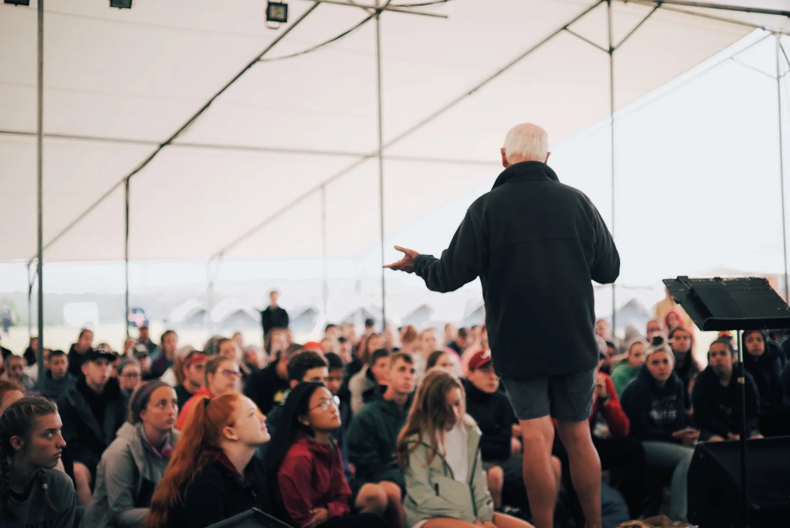 A man preaching to a crowd of students.