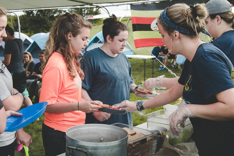 A group of Royal Servants participants serving a meal.